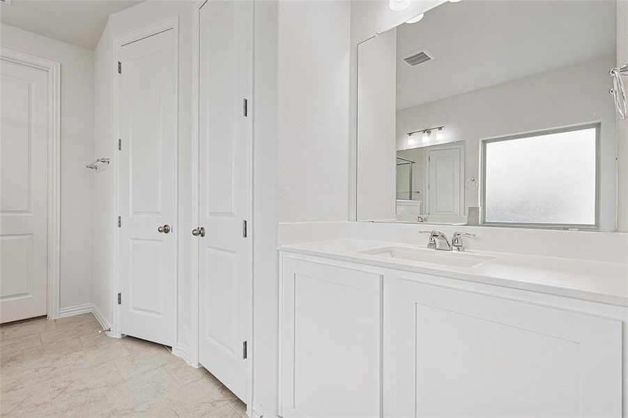 Bathroom with vanity and a closet