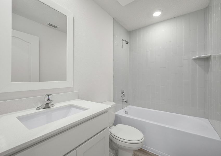 The secondary bathroom includes a beautifully tiled shower tub combination