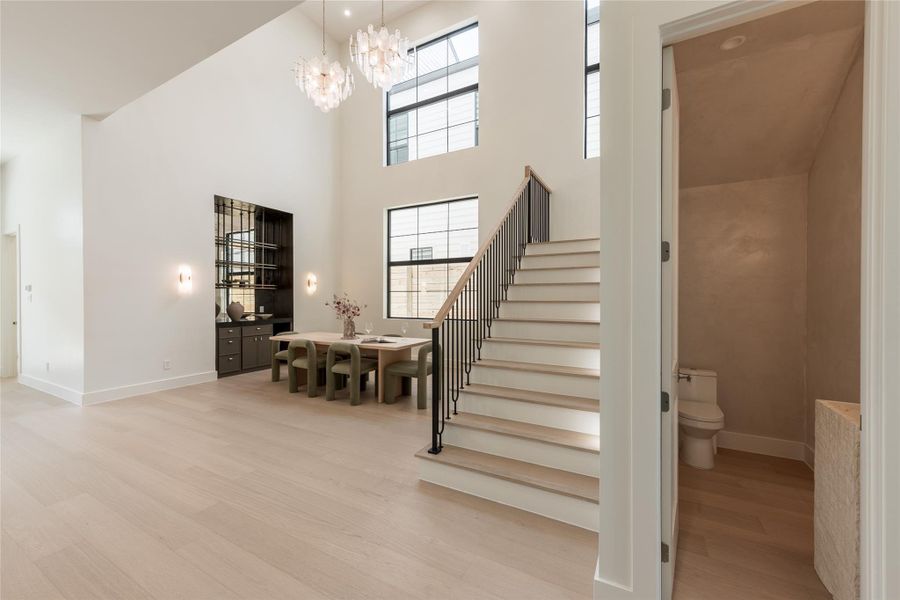 The two story dining room turns vertical volume into part of the experience, with soaring ceilings, elevated windows and an open staircase creating a dramatic setting for entertaining. The two story dining room turns vertical volume into part of the experience, with soaring ceilings, elevated windows and an open staircase creating a dramatic setting for entertaining.