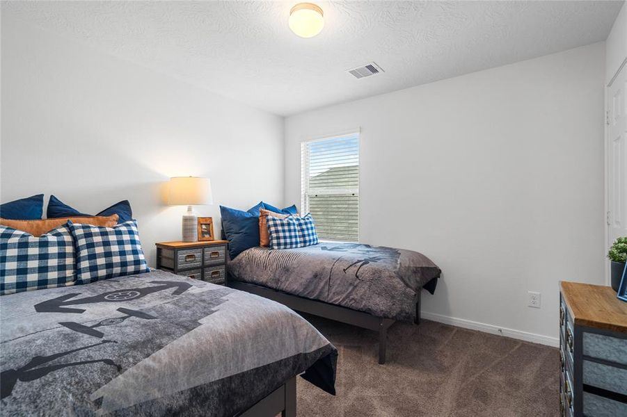 Secondary bedroom features plush carpet, neutral paint, lighting, large windows with privacy blinds and ample sized closet space.