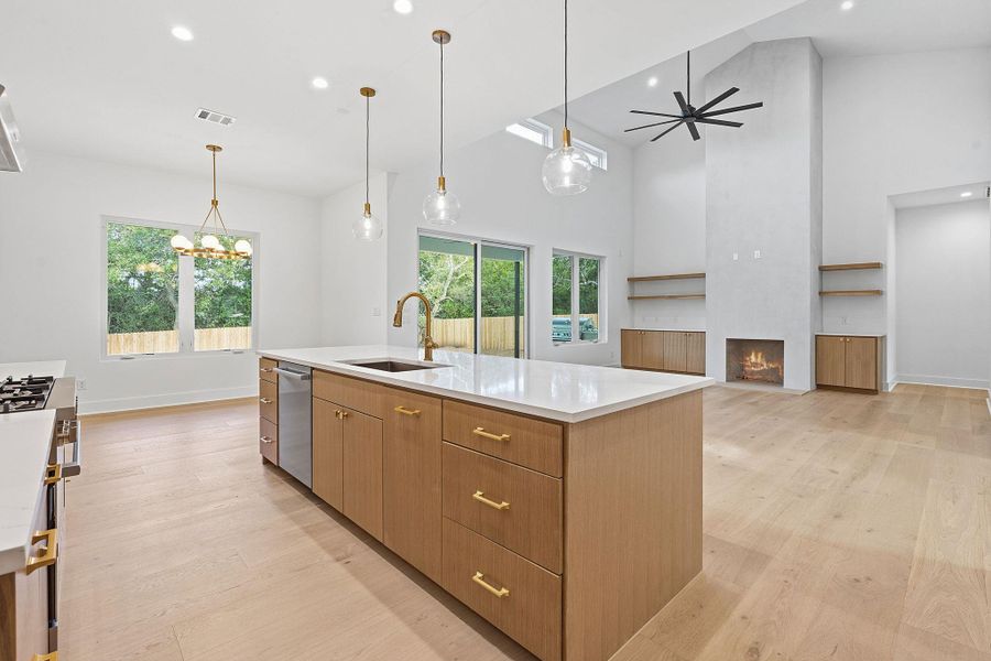 Soaring vaulted ceilings and rich wood floors frame this light-filled open-concept kitchen and living area.