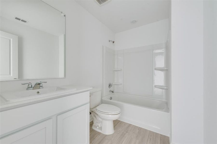 Full bathroom featuring wood-type flooring, vanity, toilet, and shower / bathtub combination