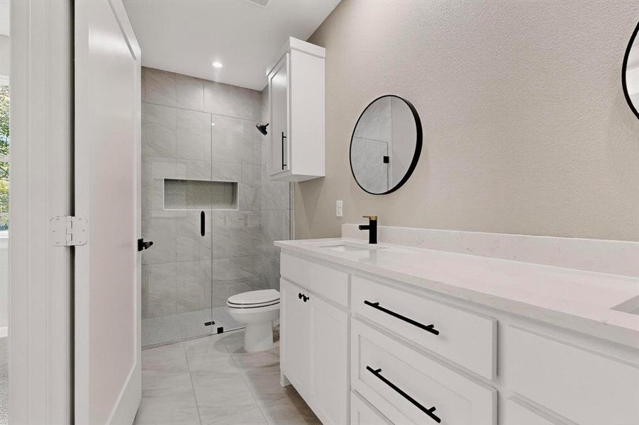 Bathroom with double vanity, a stall shower, recessed lighting, and light tile patterned floors Bathroom with double vanity, a stall shower, recessed lighting, and light tile patterned floors