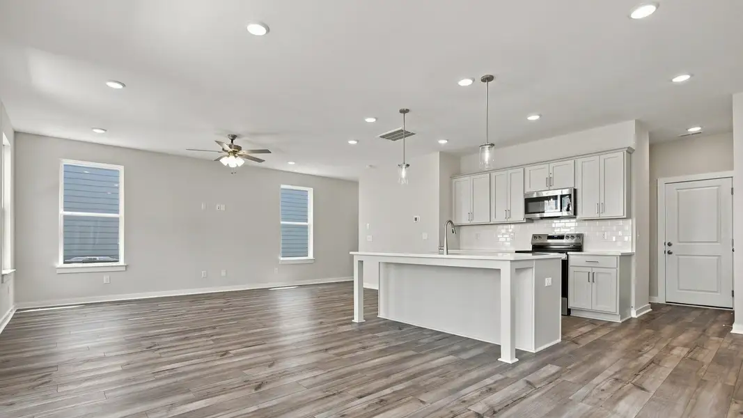 Angled view of kitchen from backyard door showing pantry door alongside convenient cabinet space Angled view of kitchen from backyard door showing pantry door alongside convenient cabinet space
