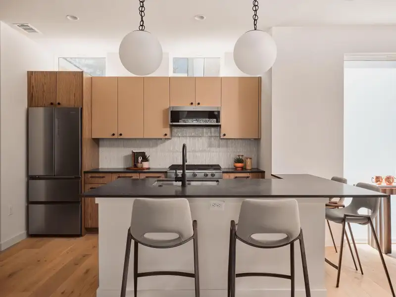 Kitchen featuring stainless steel appliances, backsplash, pendant lighting, and a breakfast bar area
