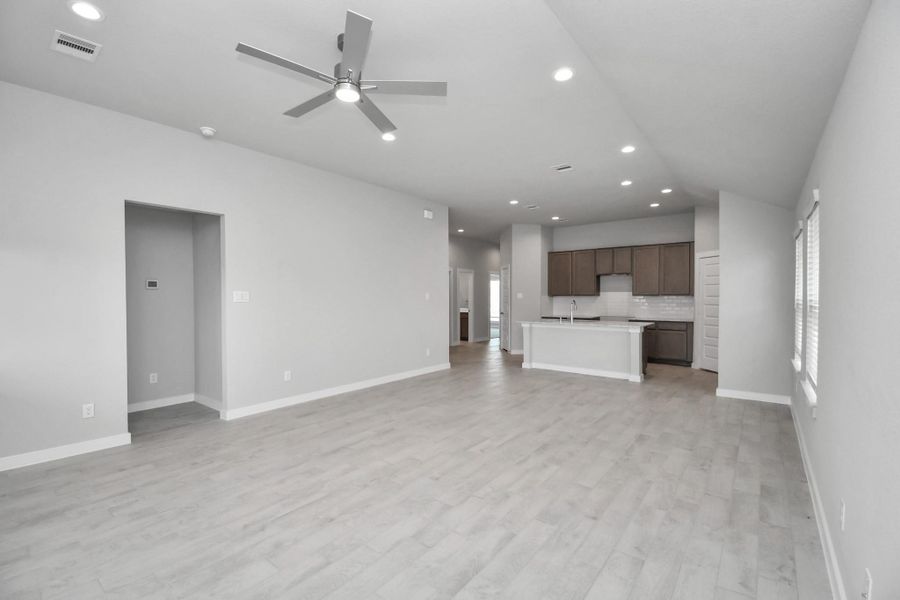 Family room flooded with natural light through the expansive windows.  The premium tile flooring adds a touch of luxury to the space, creating the perfect setting for relaxing moments and cherished gatherings with loved ones.