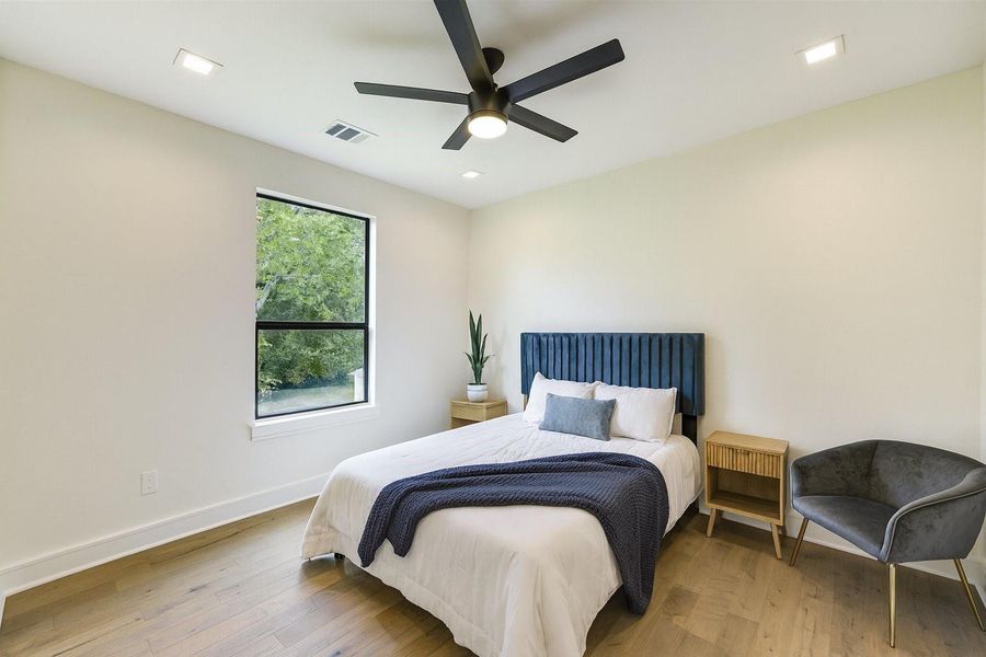 Bright secondary bedroom with modern finishes, large window for natural light, and a clean, comfortable layout.