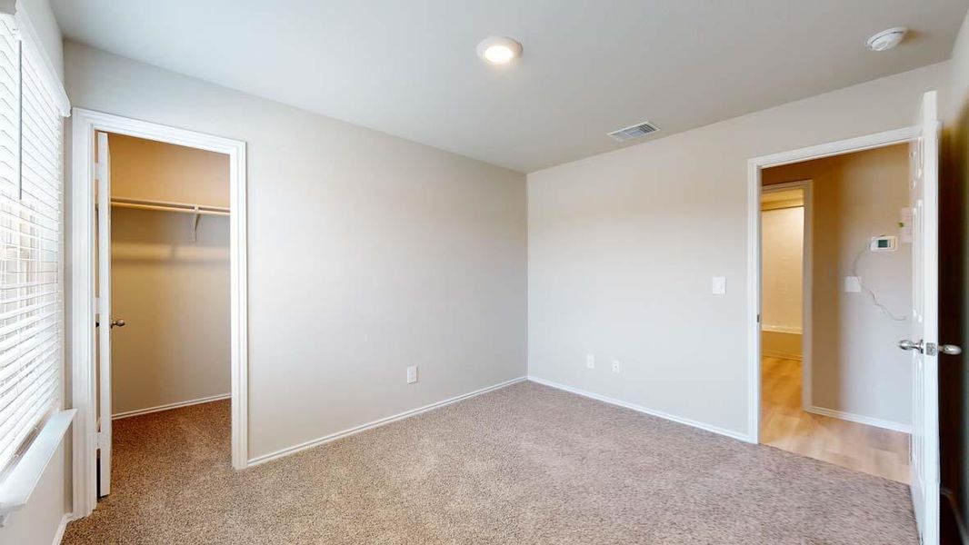 Carpeted room featuring a built-in closet with shelving, window blinds, and recessed lighting