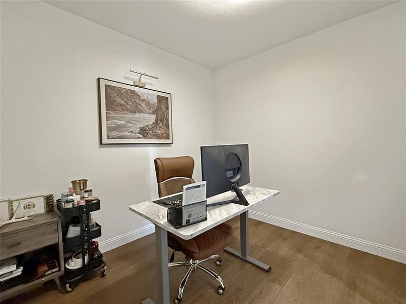 Home office featuring dark wood-type flooring and baseboards Home office featuring dark wood-type flooring and baseboards