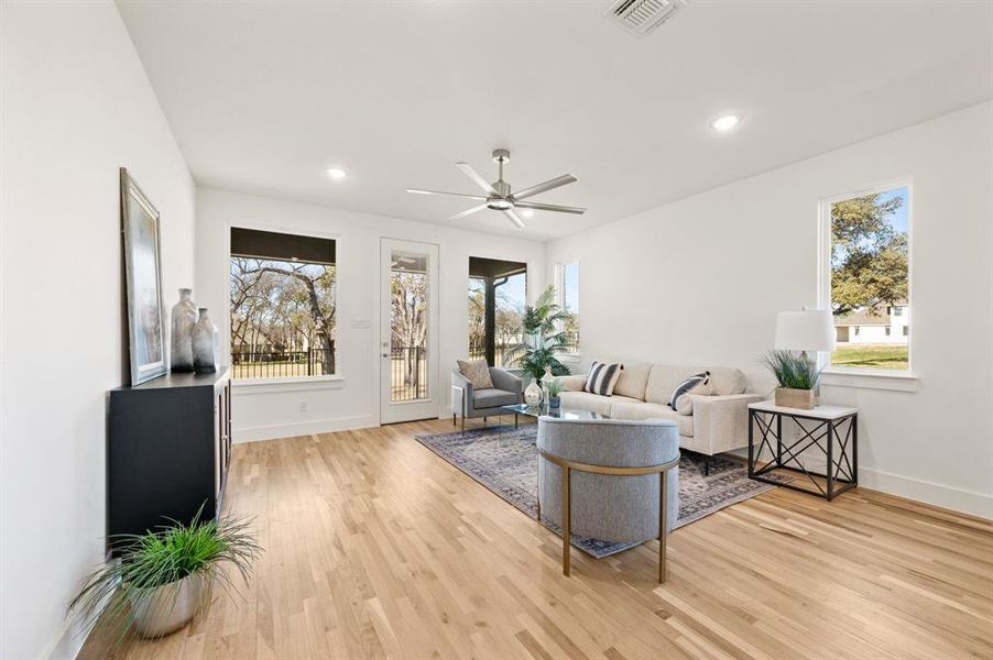 Living area with light wood finished floors, a ceiling fan, plenty of natural light, and recessed lighting
