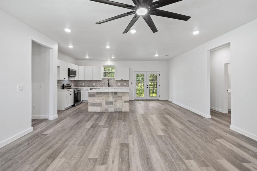 A spacious, open-concept layout with light wood-style flooring and a contemporary kitchen. A spacious, open-concept layout with light wood-style flooring and a contemporary kitchen.