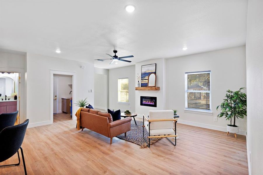 Living room with ceiling fan, plenty of natural light, and light hardwood / wood-style flooring