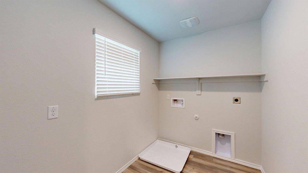 Dedicated utility room featuring wood-finish flooring, a functional window with blinds, and a built-in wall shelf Dedicated utility room featuring wood-finish flooring, a functional window with blinds, and a built-in wall shelf