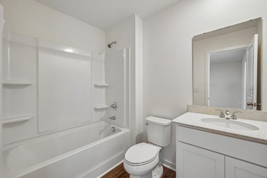 A bathroom with a tub sink and toilet.