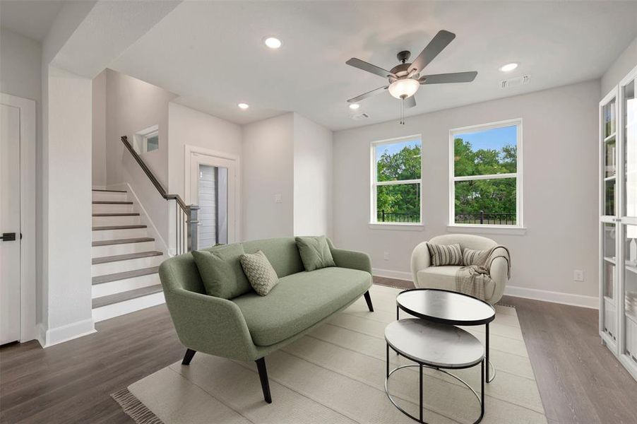 Living area featuring wood-finish flooring, recessed lighting, and a ceiling fan Living area featuring wood-finish flooring, recessed lighting, and a ceiling fan