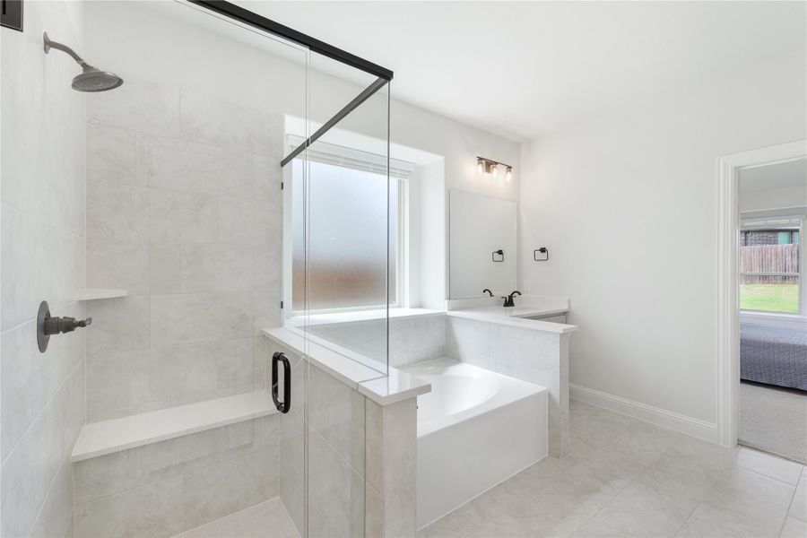 Ensuite bathroom with glass walk-in shower, soaking tub, and tile floors Ensuite bathroom with glass walk-in shower, soaking tub, and tile floors