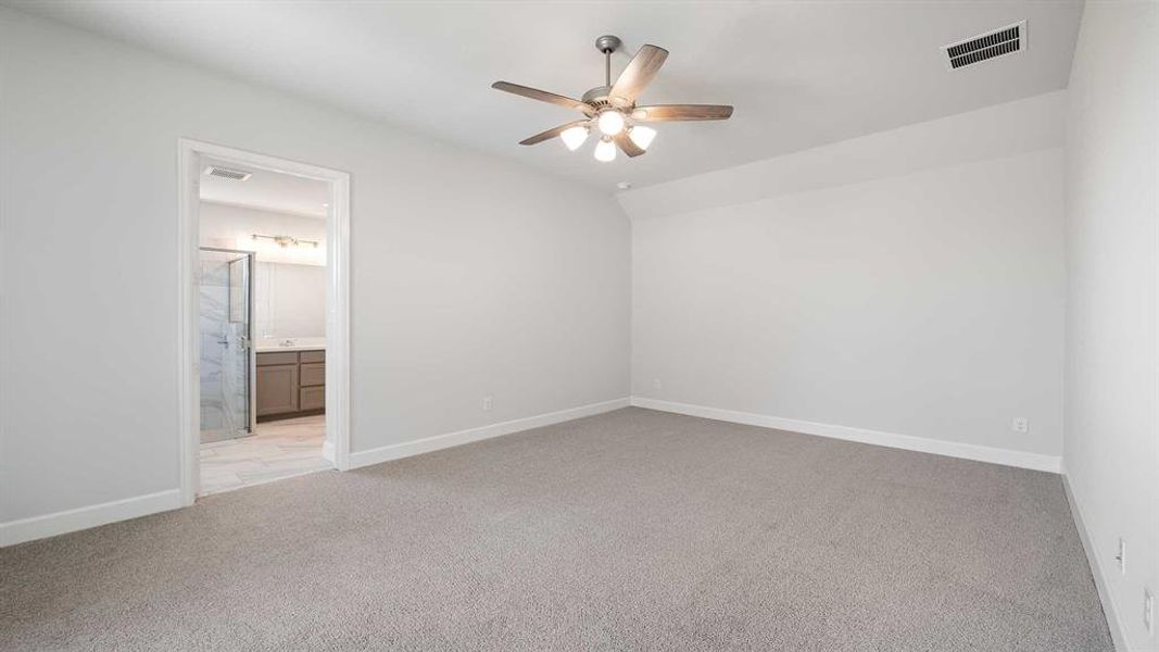 Unfurnished bedroom with ensuite bath, light carpet, and ceiling fan