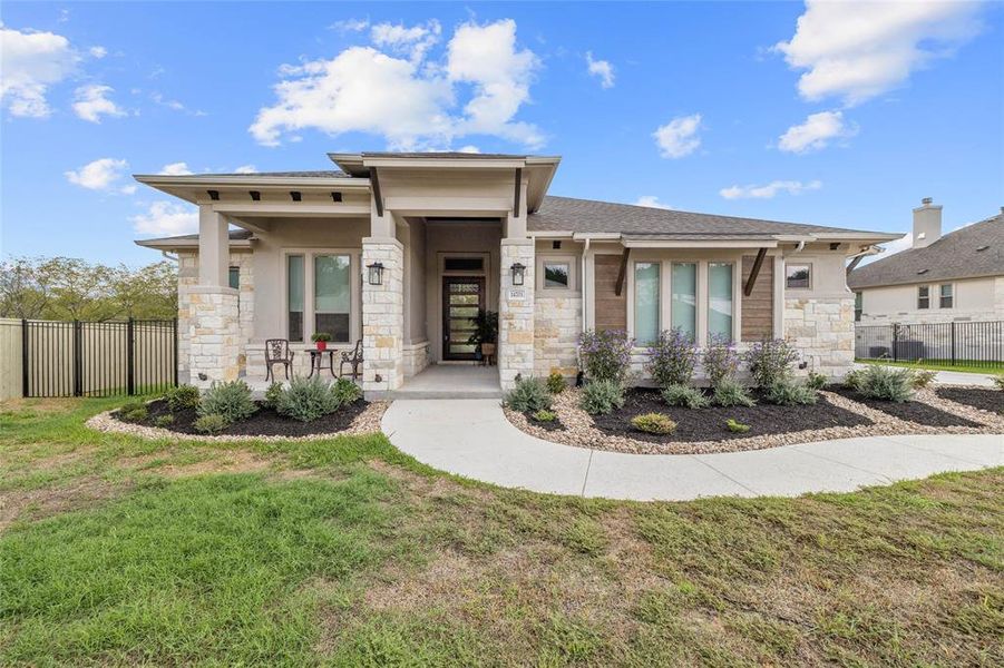 Stone and Stucco Elevation with Covered Front porch, Gutters, Corbels and Charming Landscaping