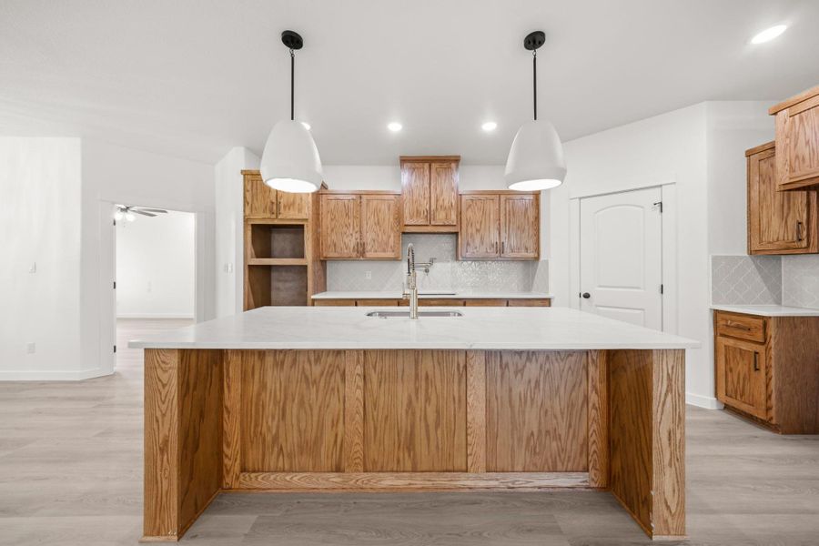 A well-lit kitchen with natural wood cabinetry and a spacious island for culinary endeavors. A well-lit kitchen with natural wood cabinetry and a spacious island for culinary endeavors.