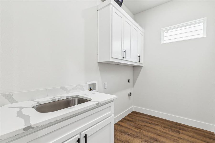 Laundry area with cabinets, dark wood-type flooring, washer hookup, sink, and hookup for an electric dryer