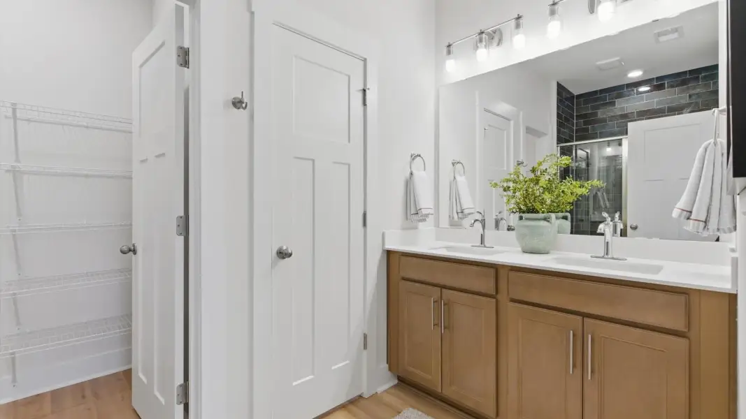 Notable primary suite with dual vanities and walk-in shower in this prime Greenville villa at Pelham Crossing