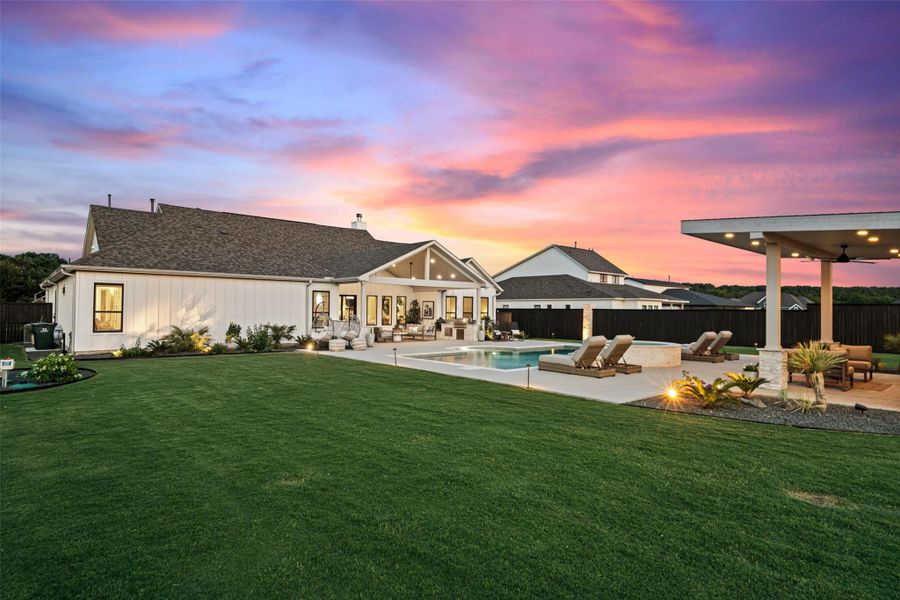 An inviting backyard oasis offers a sparkling pool and a covered patio, perfect for evening entertainment. An inviting backyard oasis offers a sparkling pool and a covered patio, perfect for evening entertainment.