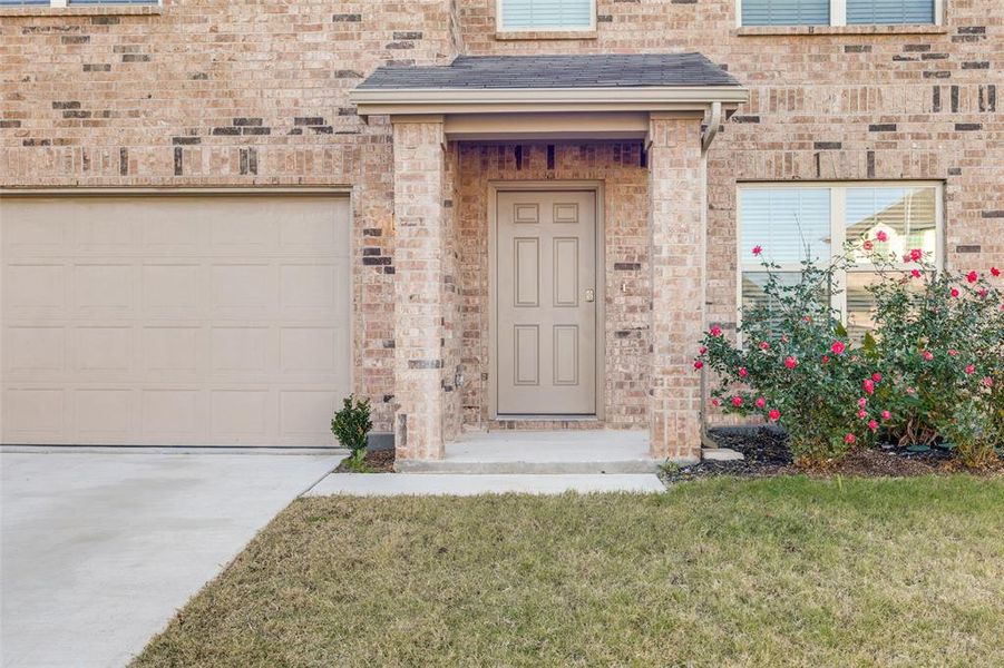 View of exterior entry with a garage