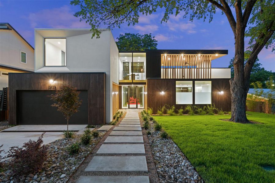 Contemporary house featuring a lawn, concrete driveway, a balcony, and an attached garage Contemporary house featuring a lawn, concrete driveway, a balcony, and an attached garage