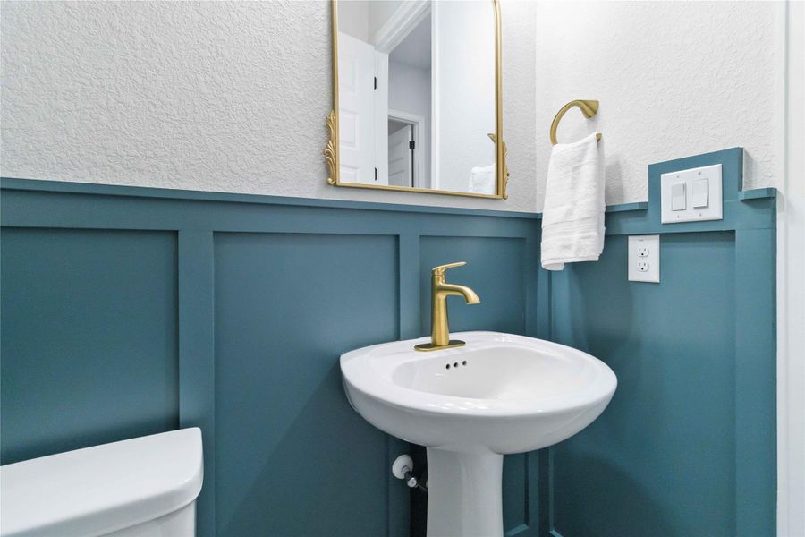 Bathroom featuring a textured wall and toilet Bathroom featuring a textured wall and toilet