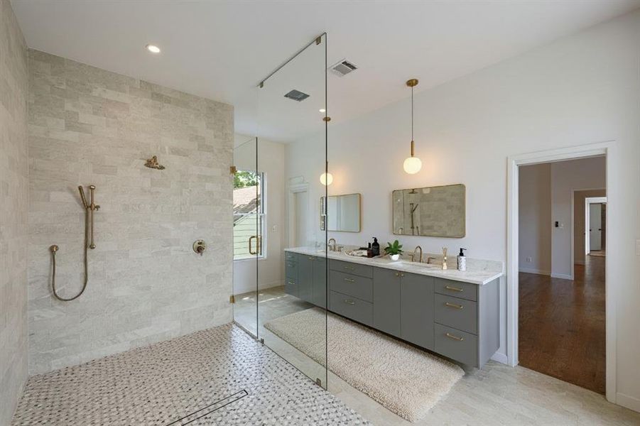 Bathroom featuring a stall shower, double vanity, and recessed lighting