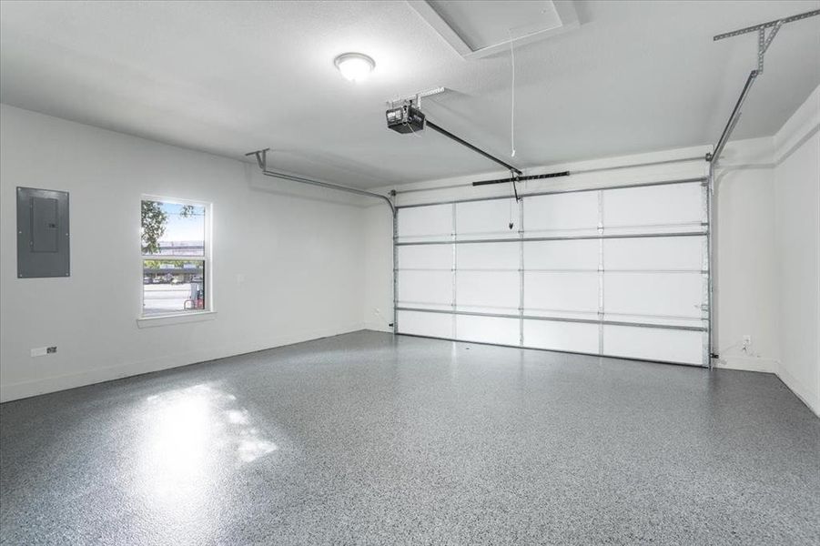 Garage with electric panel and a garage door opener