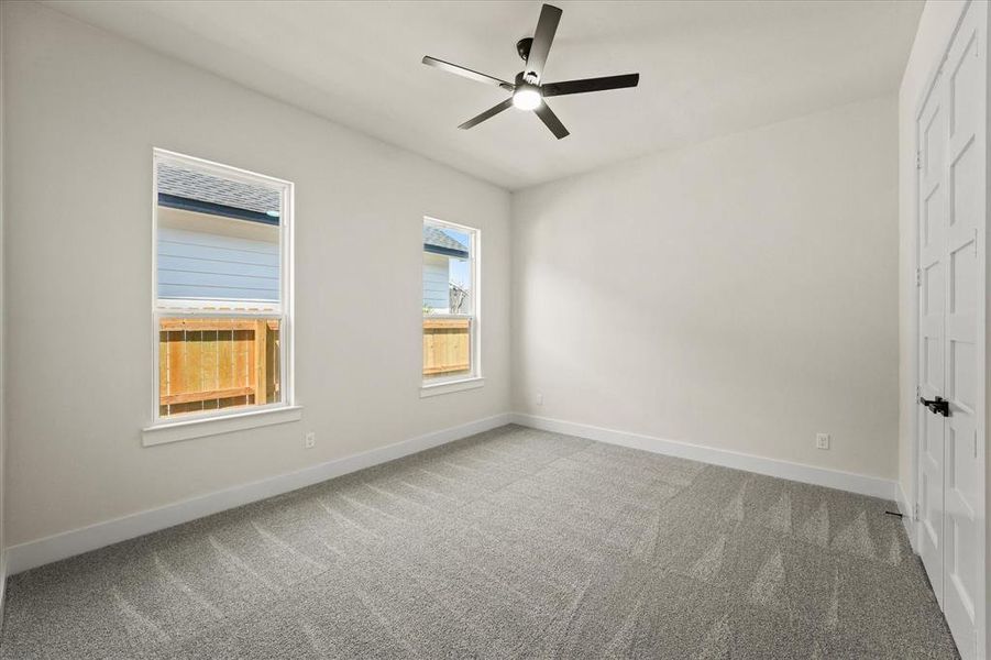 Empty room featuring light carpet and a ceiling fan Empty room featuring light carpet and a ceiling fan