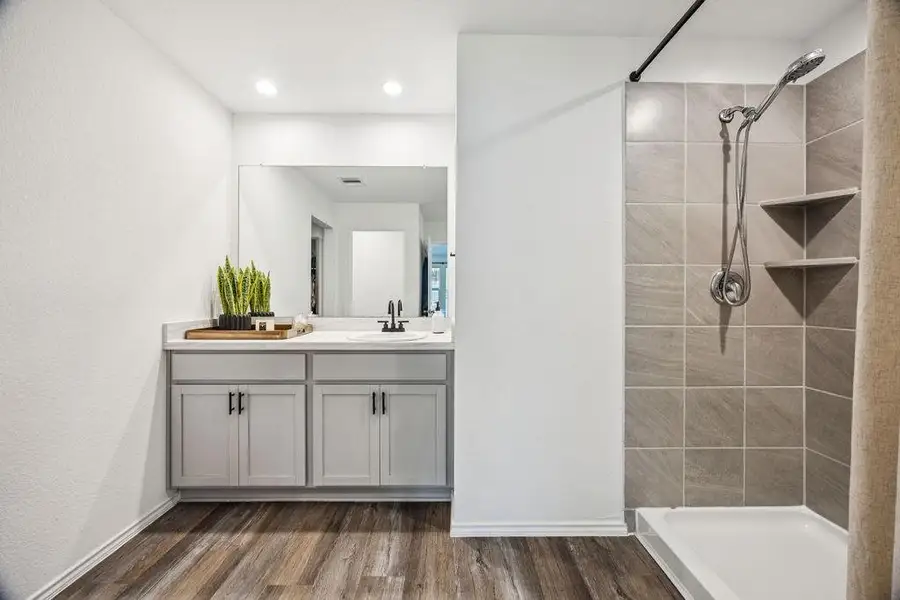 Serene primary bathroom featuring a spacious vanity, sleek tile shower, and modern finishes. Serene primary bathroom featuring a spacious vanity, sleek tile shower, and modern finishes.