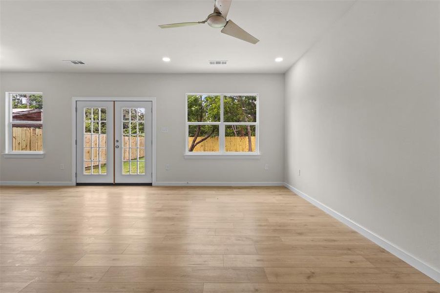 Spacious room featuring wood-finish flooring, recessed lighting, and a modern ceiling fan
