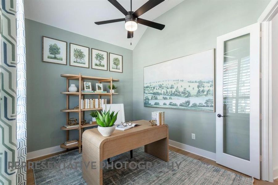 Home office featuring wood finished floors, lofted ceiling, and a ceiling fan