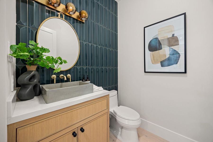 A stunning powder bath that blends bold design with modern elegance, featuring a sleek floating vanity, vessel sink, and warm wood cabinetry. Rich vertical tile creates depth and texture, while brass fixtures add a touch of luxury. The highlight of this space is the dramatic statement tile accent wall, elevating the entire room with a designer feel that leaves a lasting impression for guests.