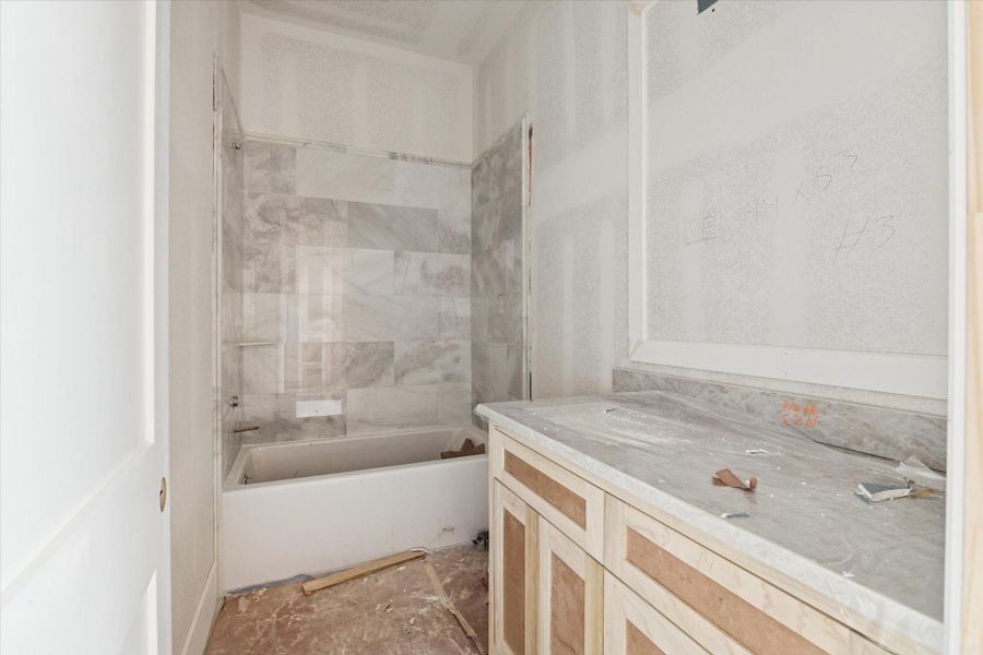 Spacious secondary bathroom with oversized vanity and tile tub surround. Spacious secondary bathroom with oversized vanity and tile tub surround.