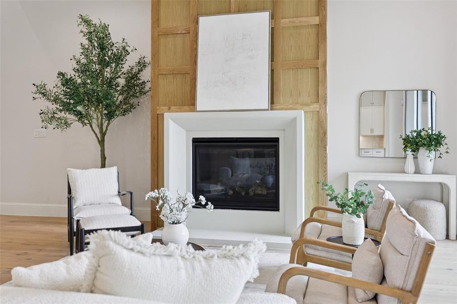 Living room with wood finished floors and a glass covered fireplace