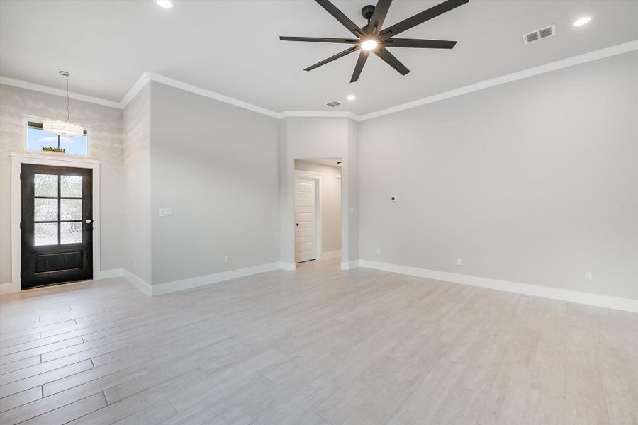 Entrance foyer with recessed lighting, visible vents, baseboards, light wood finished floors, and crown molding