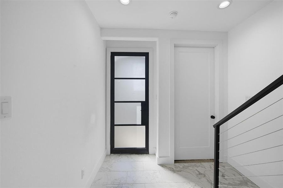 Entrance foyer with light marble finish floors and recessed lighting