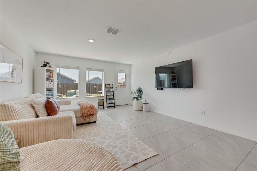 Living area featuring light tile patterned floors and baseboards Living area featuring light tile patterned floors and baseboards