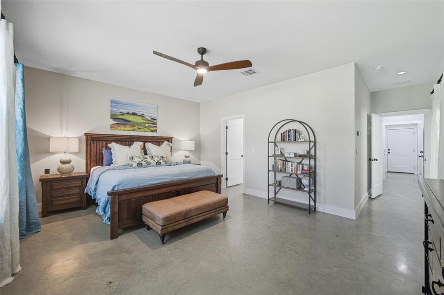 Bedroom featuring finished concrete floors and a ceiling fan Bedroom featuring finished concrete floors and a ceiling fan