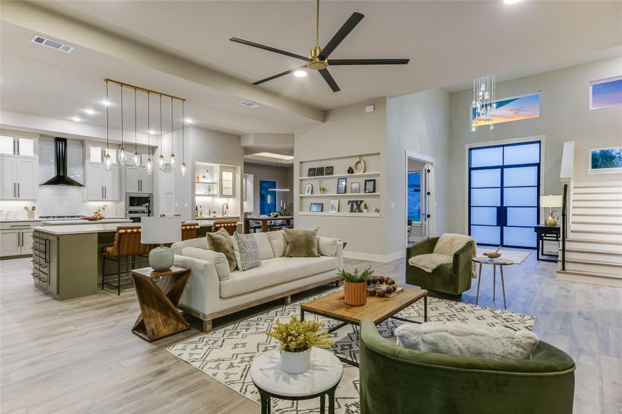 Living area featuring light wood-style floors, ceiling fan, and recessed lighting Living area featuring light wood-style floors, ceiling fan, and recessed lighting