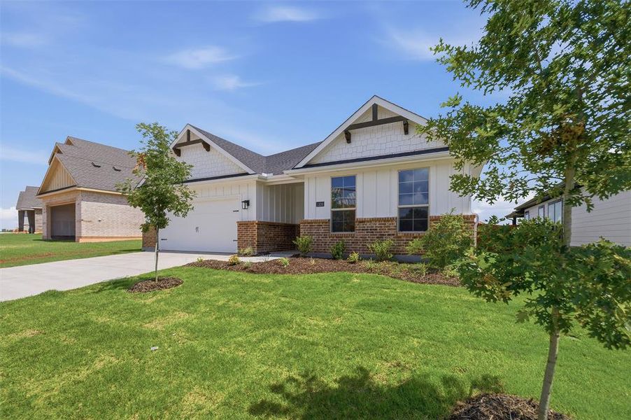 Contemporary home exterior featuring white vertical siding, brick accents, and dark trim details Contemporary home exterior featuring white vertical siding, brick accents, and dark trim details