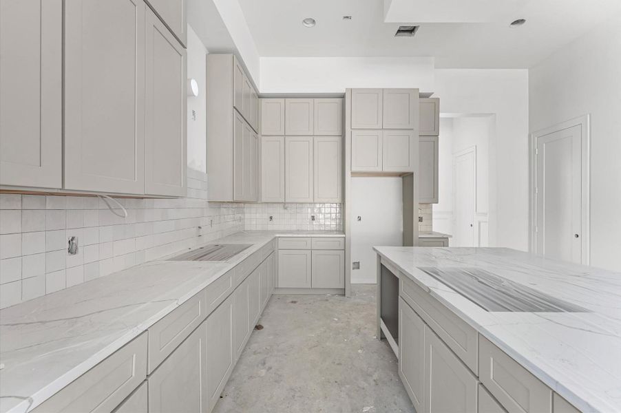 Kitchen with large island, shaker cabinets and ample storage.