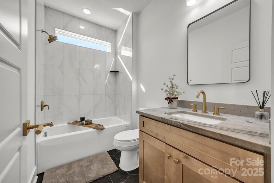 Guest bathroom with tiled flooring, quartz countertops, gold finishes Guest bathroom with tiled flooring, quartz countertops, gold finishes