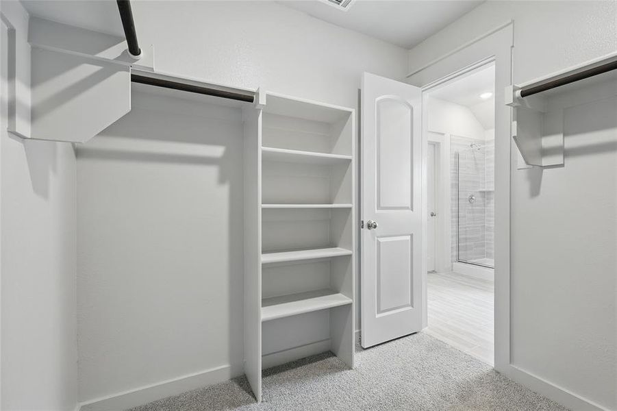 Walk in closet featuring light colored carpet Walk in closet featuring light colored carpet