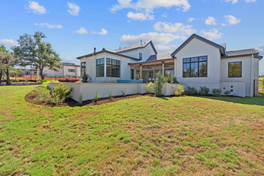 Rear view of house featuring a lawn, fence, and stucco siding Rear view of house featuring a lawn, fence, and stucco siding