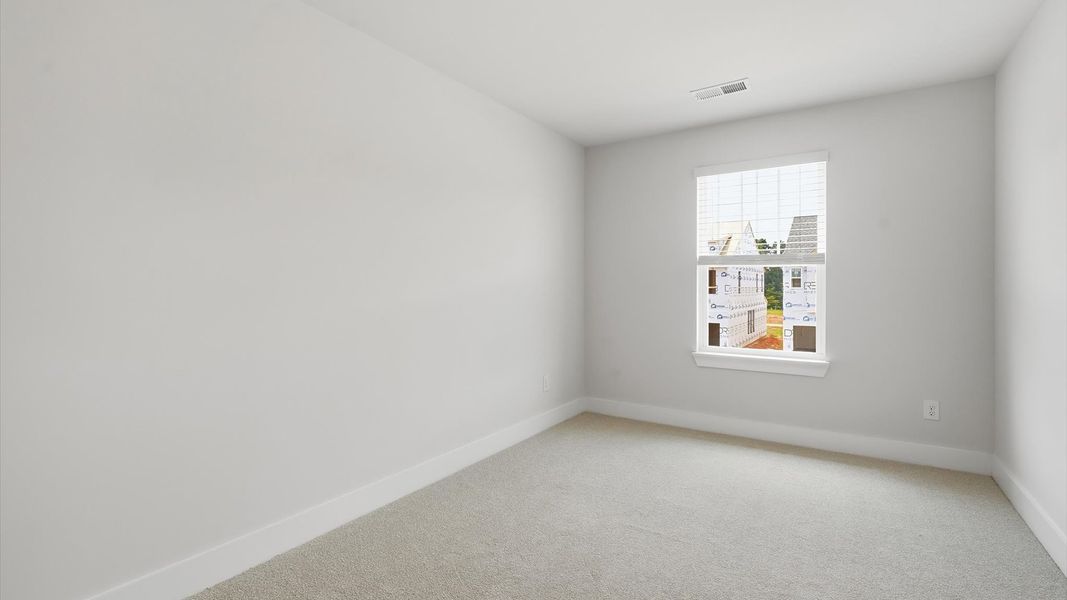Superior comfort in a secondary bedroom with plush carpet and an oversized walk-in closet