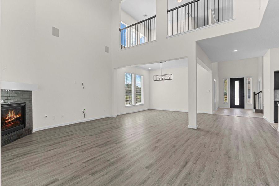 Spacious primary suite entry flows seamlessly into the family areas, showcasing soaring ceilings, elegant flooring, and a cozy fireplace. Spacious primary suite entry flows seamlessly into the family areas, showcasing soaring ceilings, elegant flooring, and a cozy fireplace.